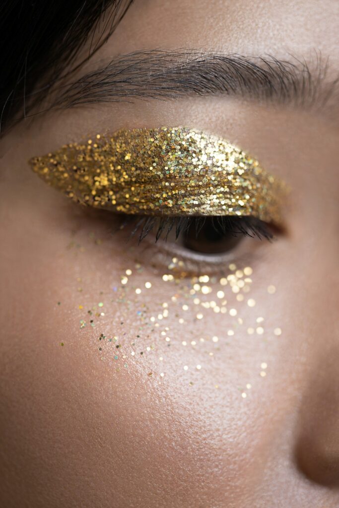 Close-up of a woman with gold glitter on her eyelids