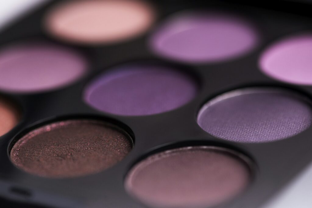 Open eyeshadow palette in cool deep tones on a soft surface