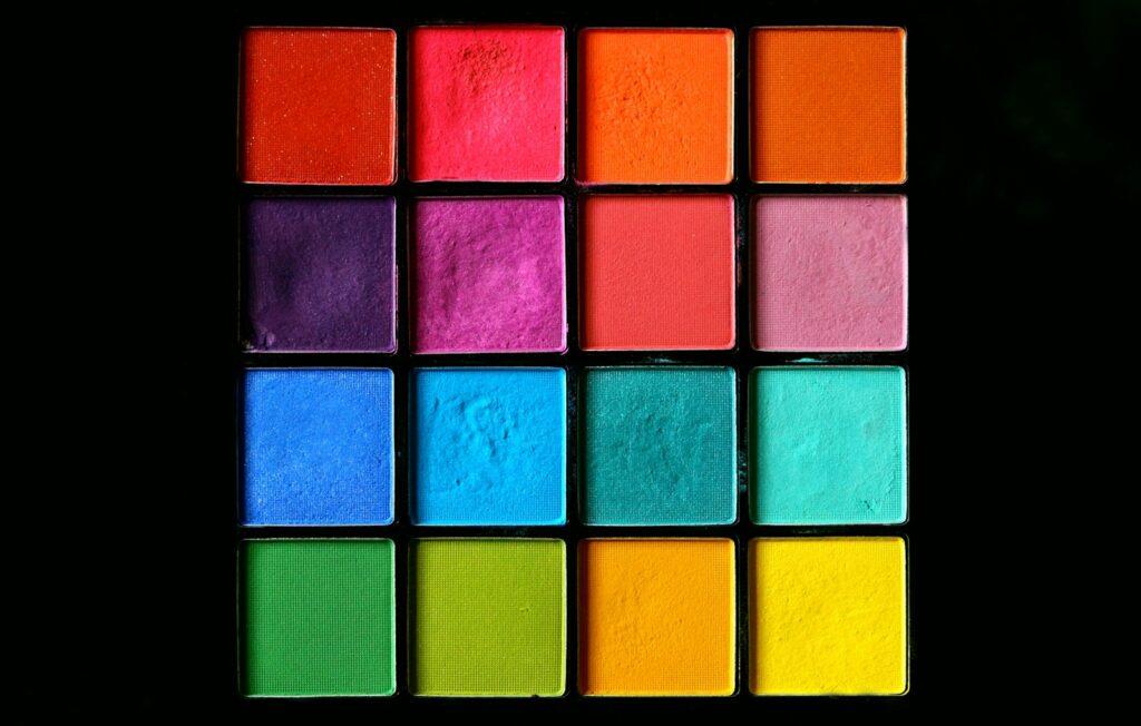 Open eyeshadow palette with brushes on a white background