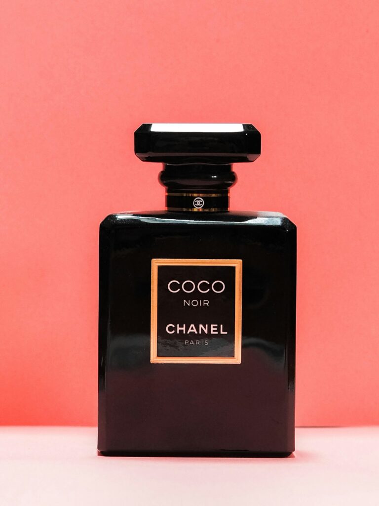 An elegant black and gold perfume bottle on a soft surface