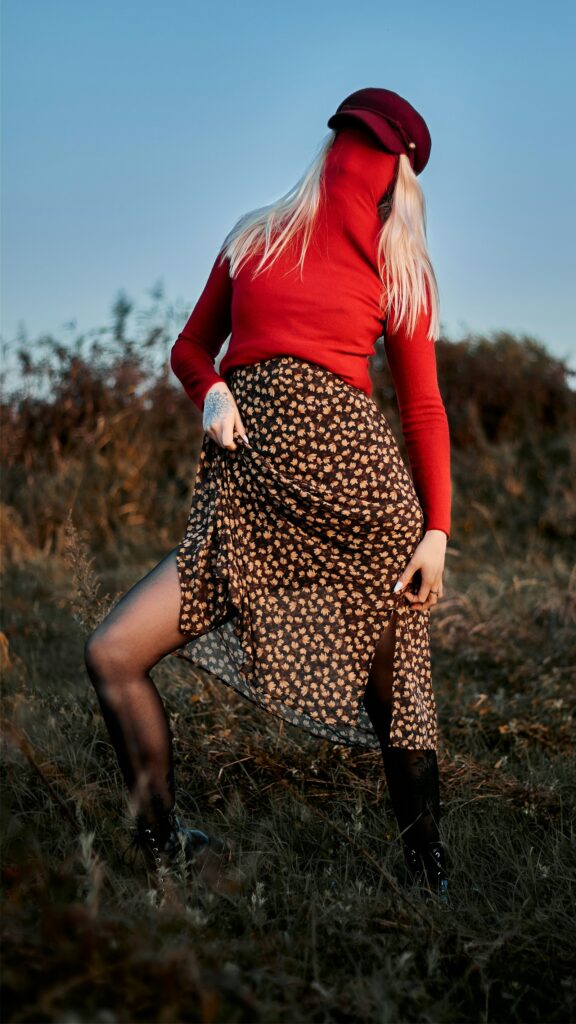 Woman in fall fashion, posing in a polka dot skirt and red top