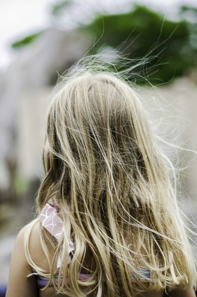 A woman with light hair blowing in the wind on a sunny day