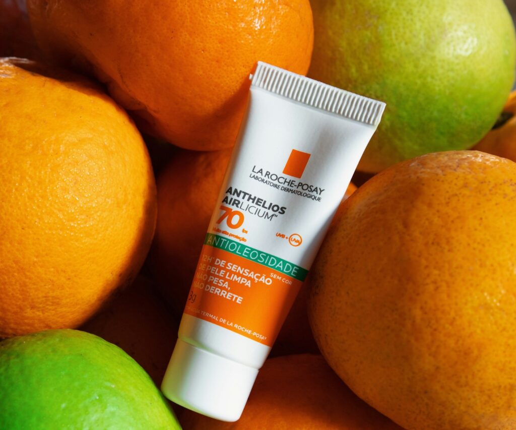 An orange and white sunscreen tube on a clean background