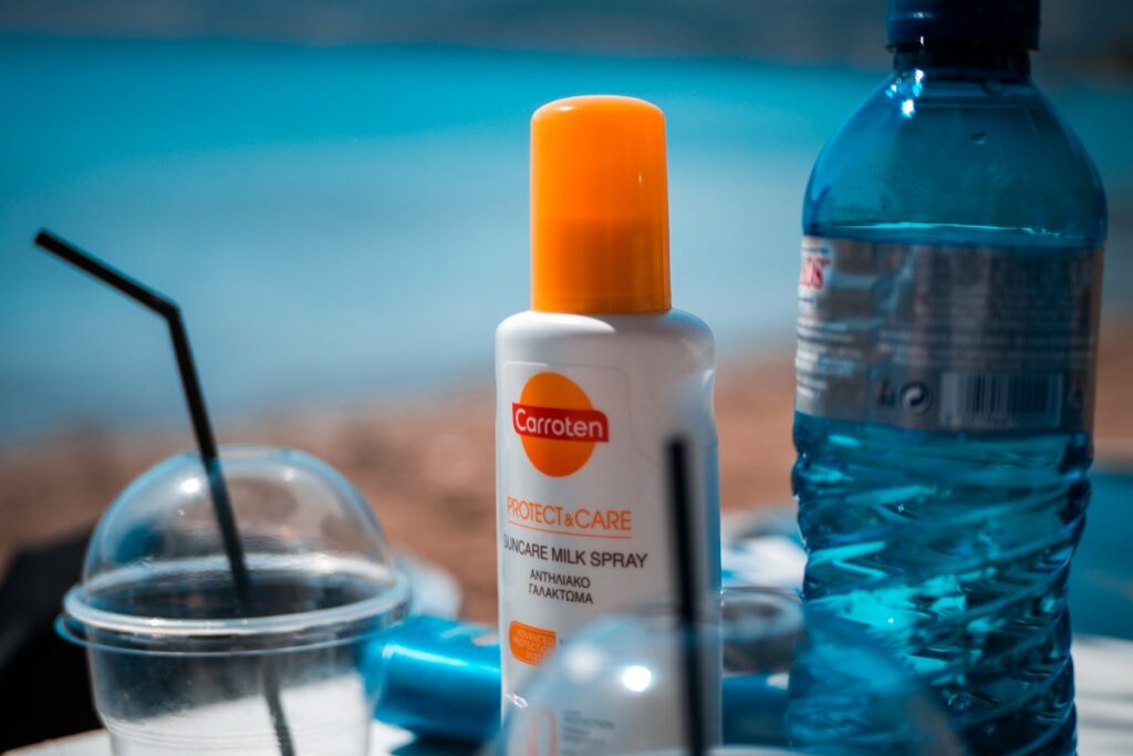 A white and orange sunscreen bottle on a blue table
