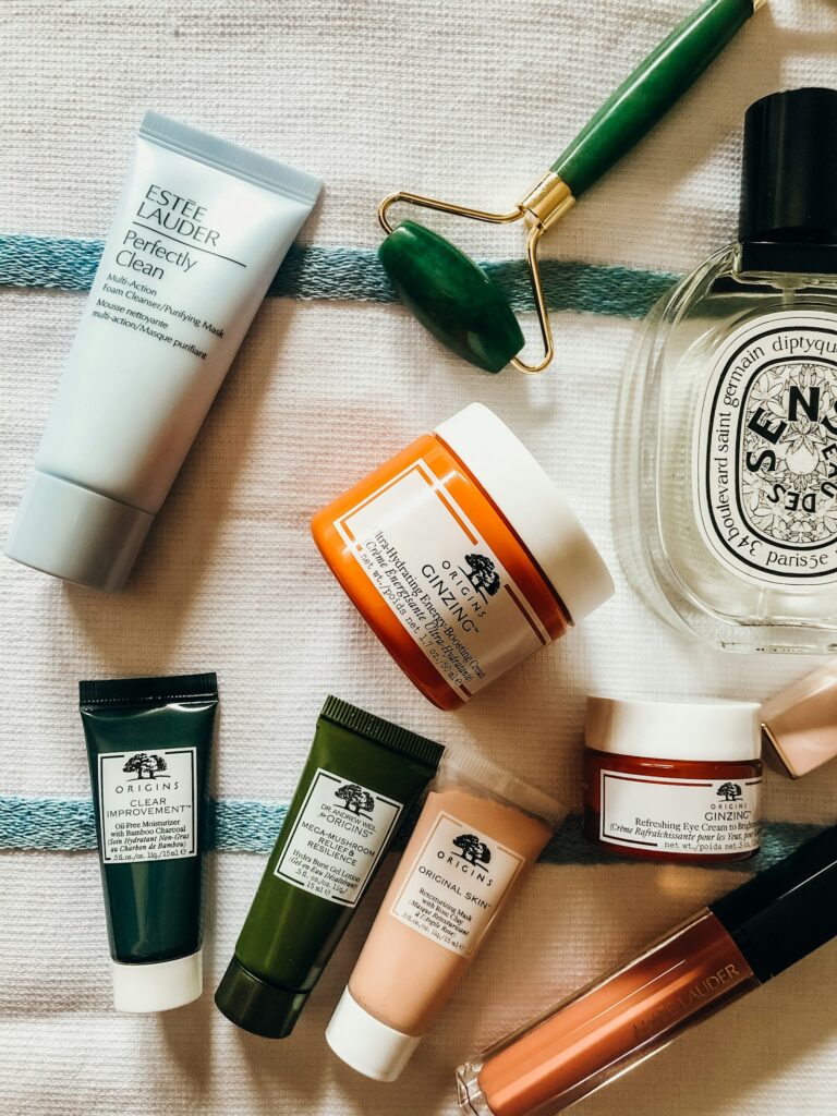 Sunscreen and skincare bottles on a sandy summer surface