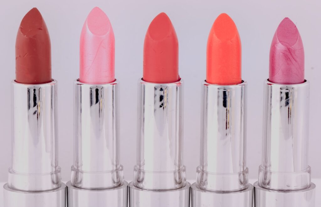 Five lipsticks in different shades arranged in a row