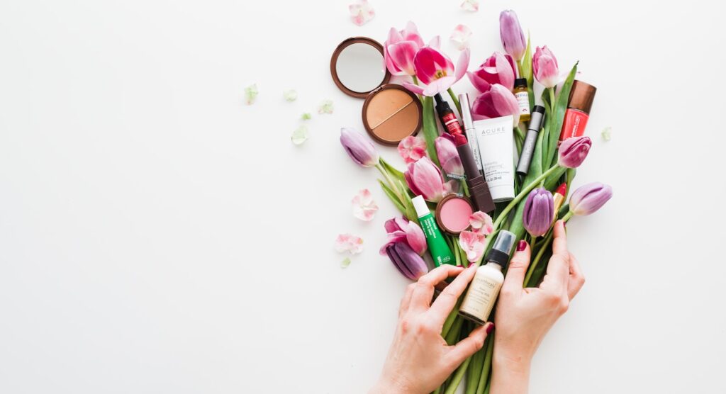 Spring florals and pastel cosmetics on a soft surface