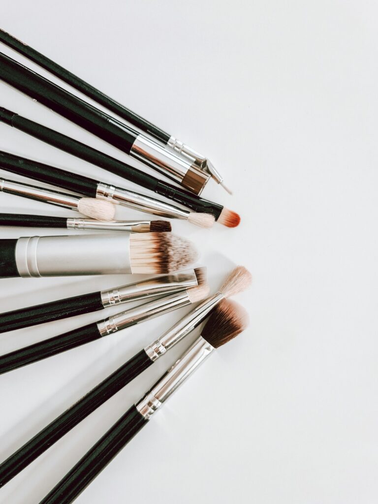 A black and brown makeup brush set arranged on a flat surface