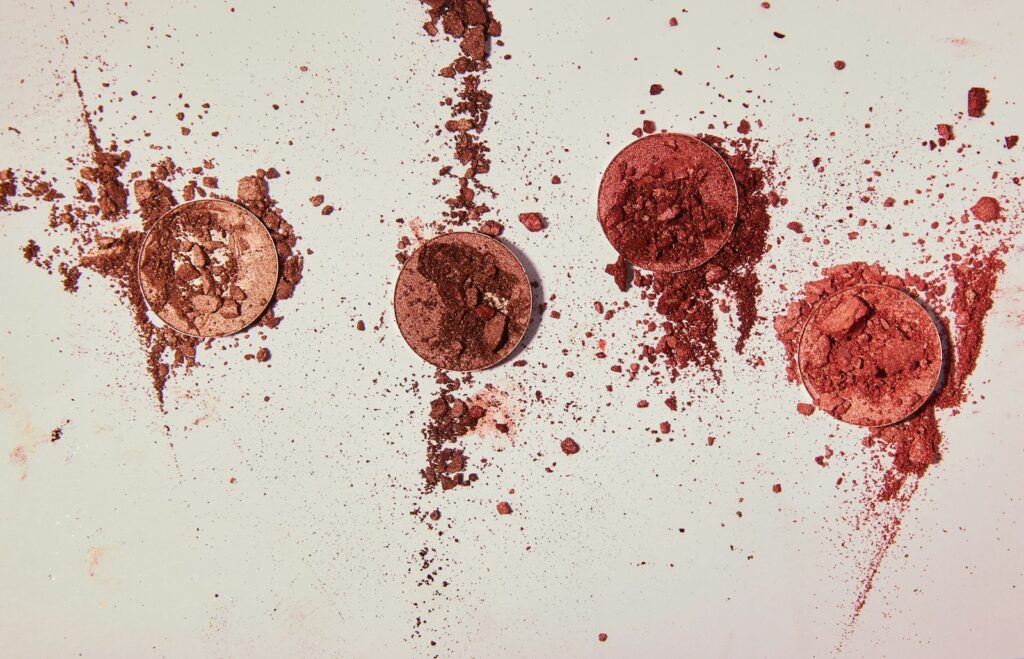 Assorted color makeup powders arranged on a flat surface