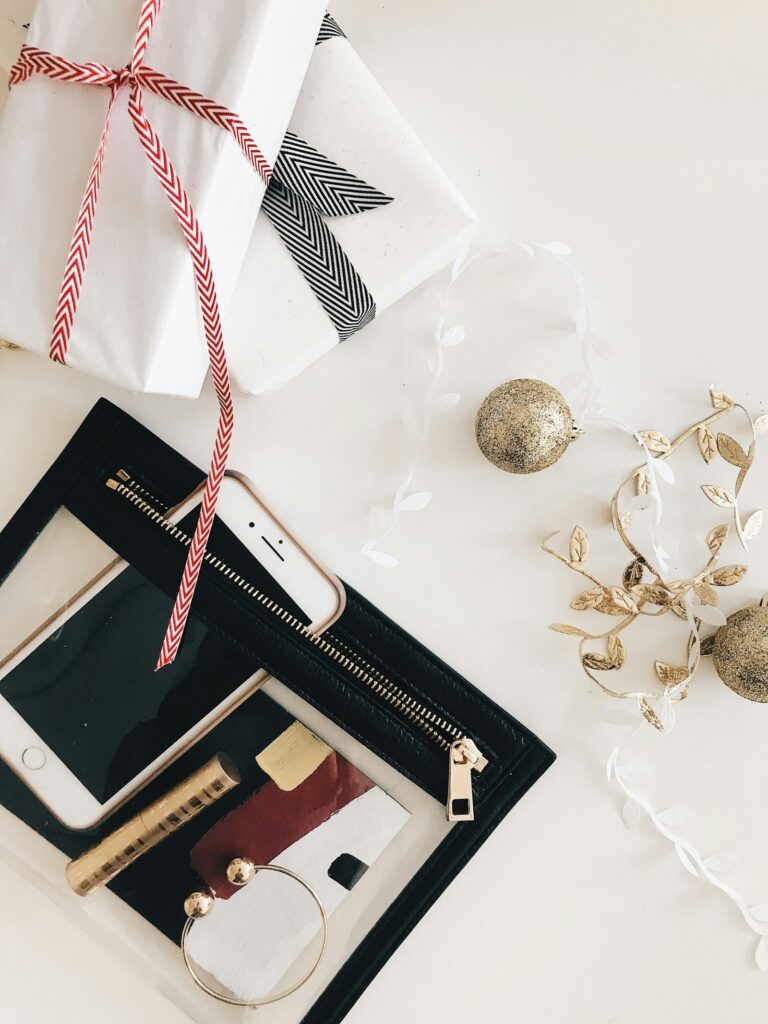 Wrapped holiday gifts and a candle on a wood surface