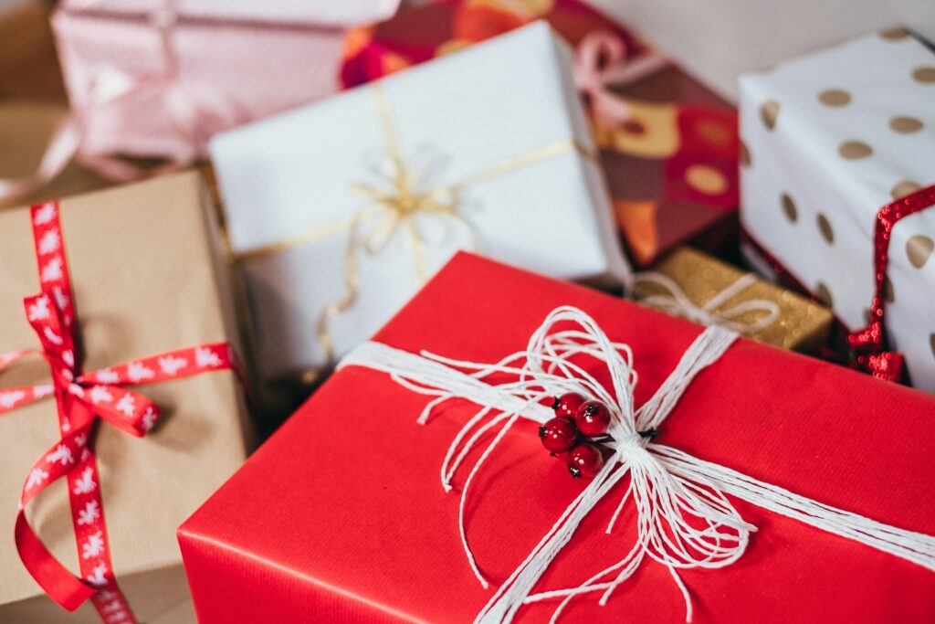 Wrapped holiday gifts on a soft white surface in warm light