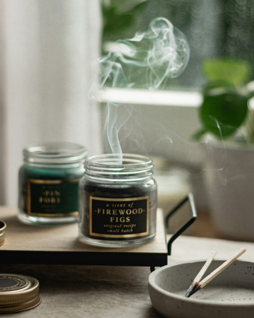 A lit candle in a glass holder against a soft warm background