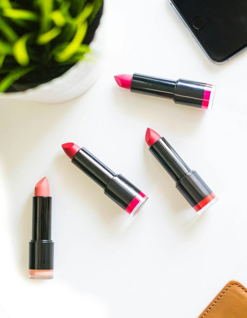 Four assorted-color lipsticks lined up on a neutral surface