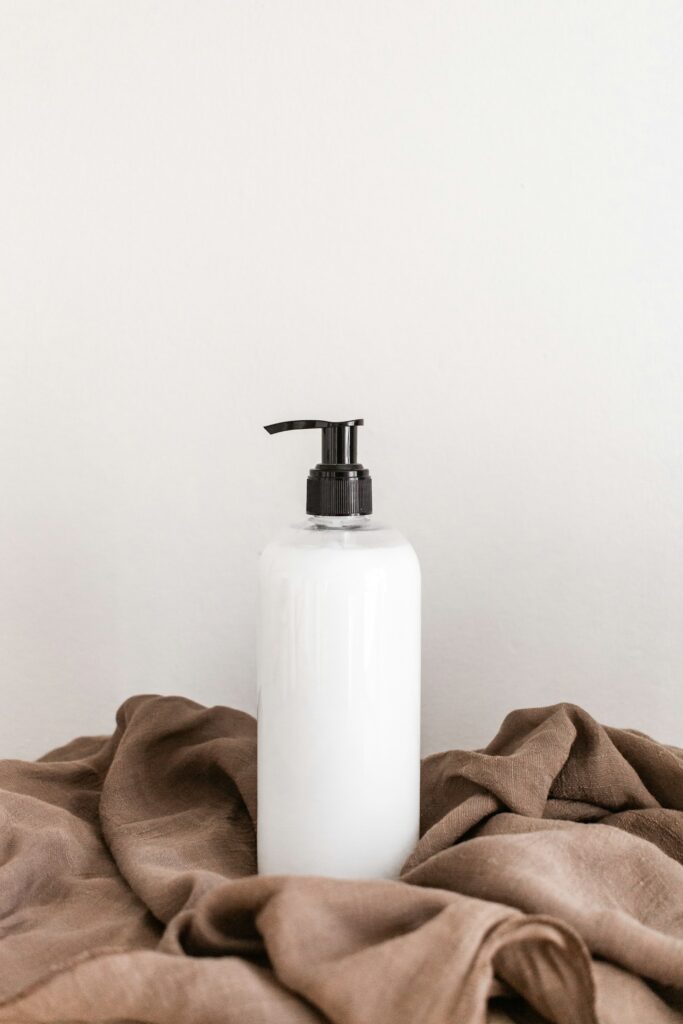 A clean white skincare bottle on a soft tabletop