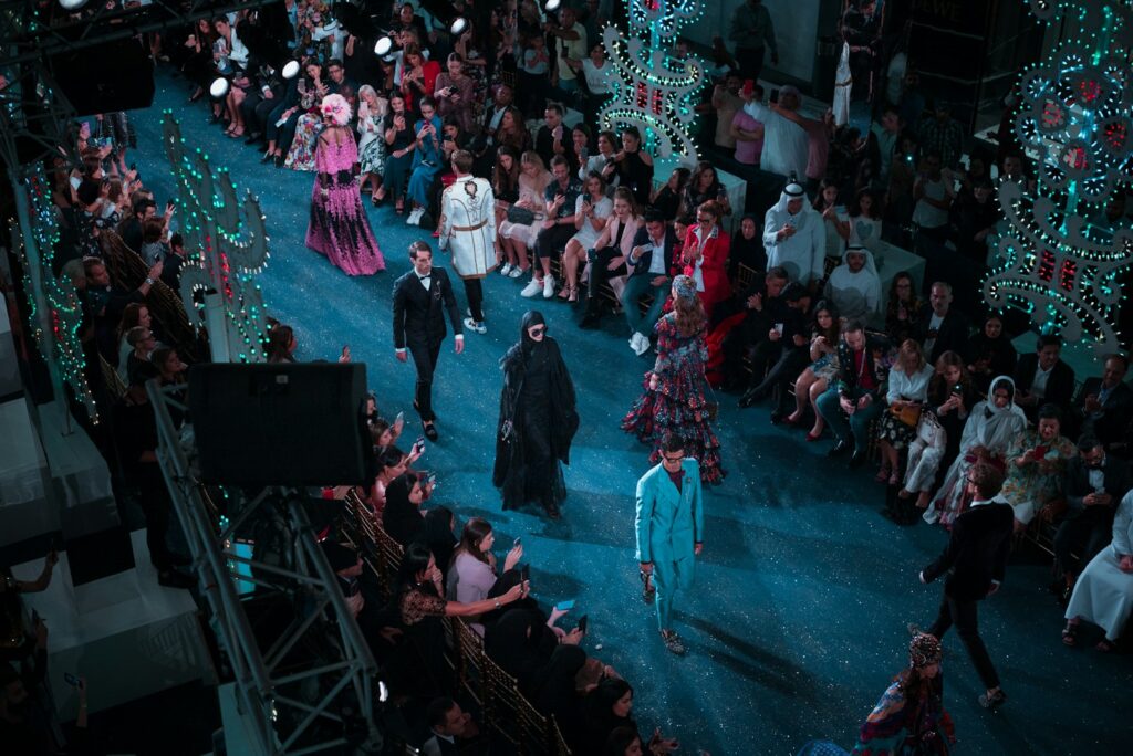 Models walking a fashion runway in soft daylight