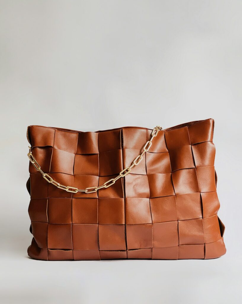 Brown structured leather handbag on a textured surface