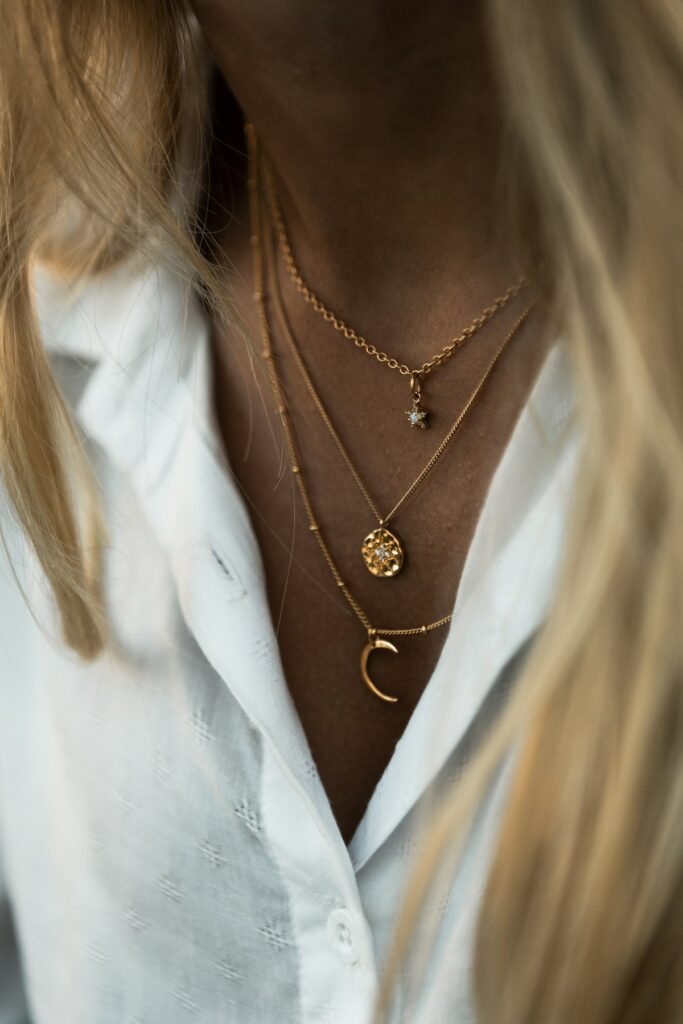 A woman in a white shirt wearing a gold pendant necklace