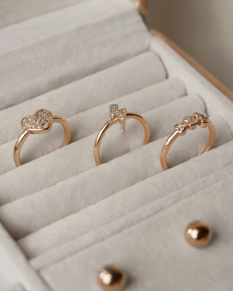 Three slim gold rings arranged inside a small white box