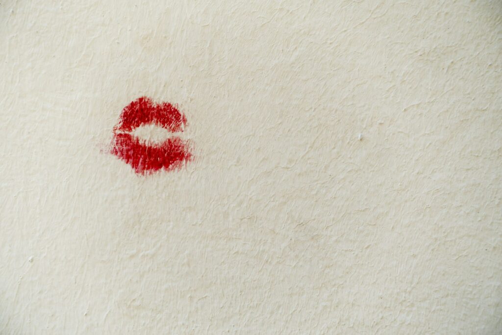 Open red lipstick tube on a soft surface