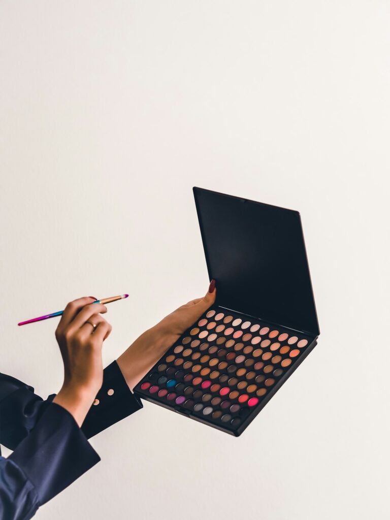 Eyeshadow palette open with brushes on soft surface
