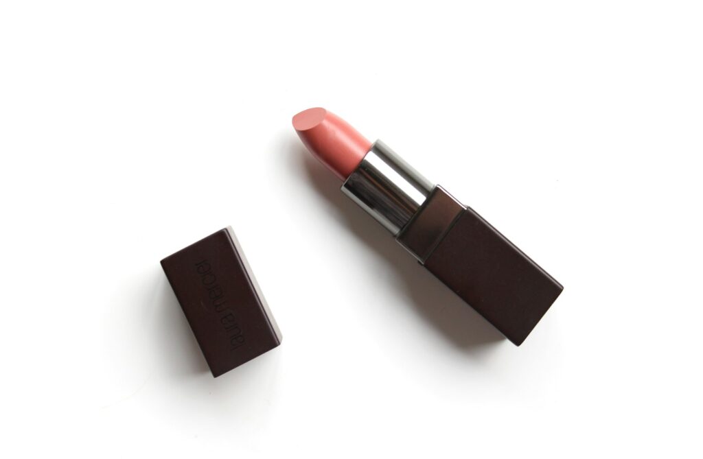 Autumn lipstick on a moody surface with warm light