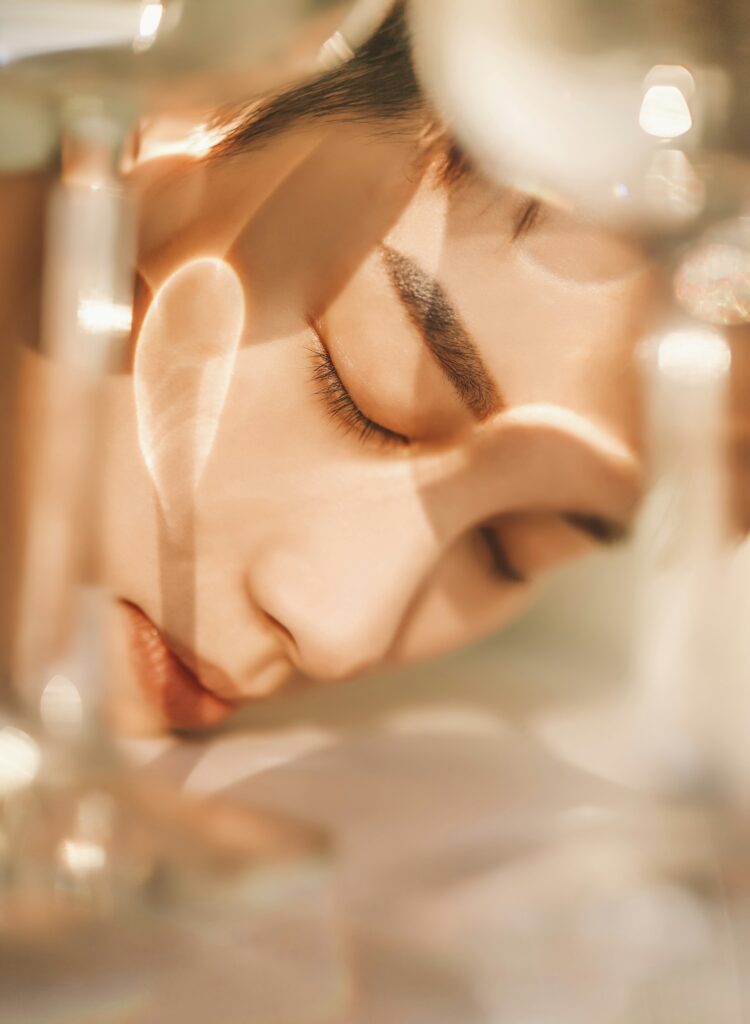 Edit of luxury beauty products and a single white flower on cream silk