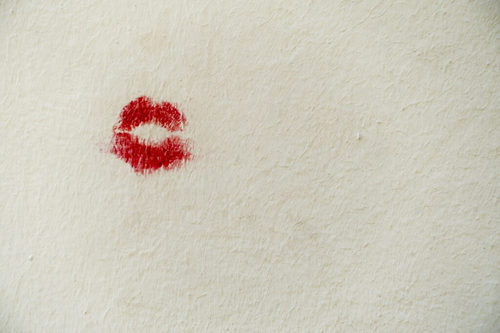 Red lipstick and beauty products on a marble surface