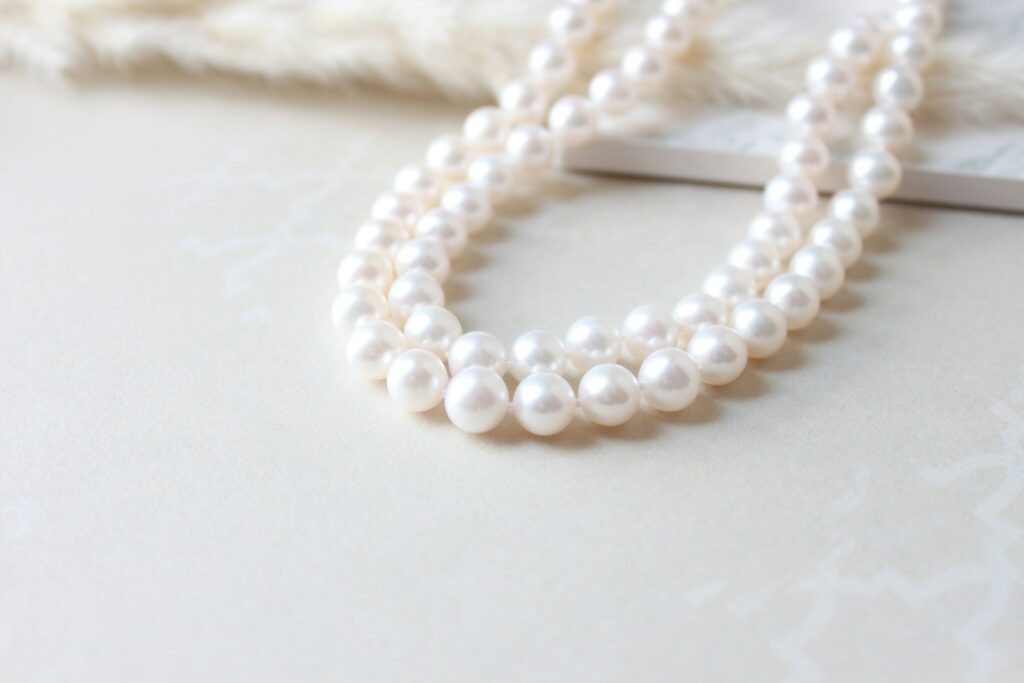 Pearl jewellery laid on a soft pastel surface
